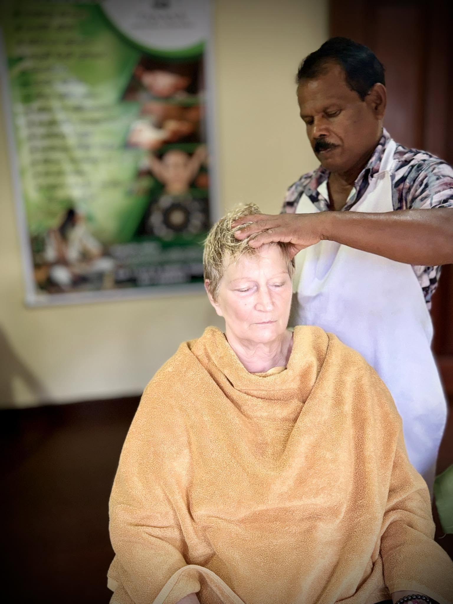 Ayurvedic practitioner providing a relaxing head treatment